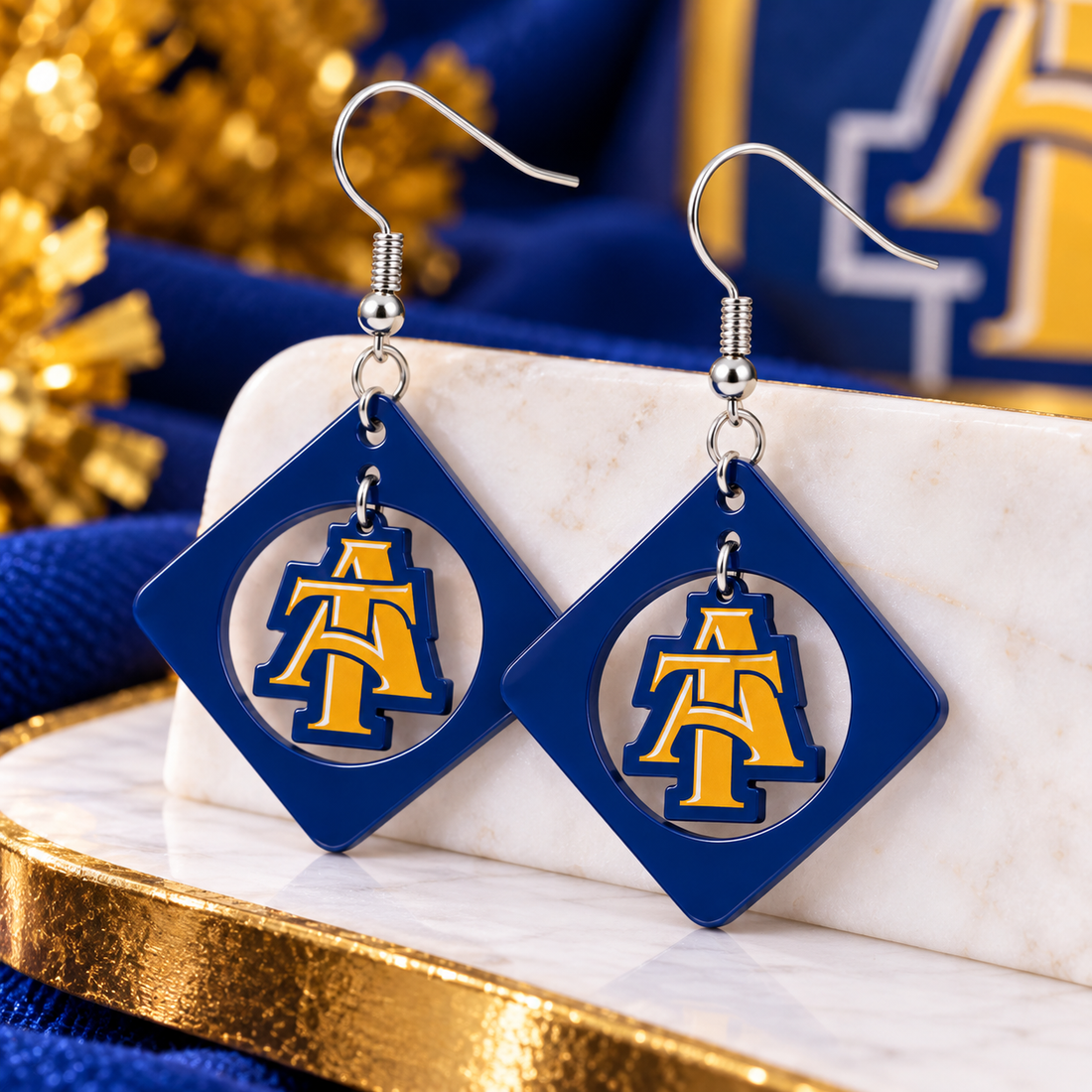 Blue and gold dangle earrings with diamond frame and swinging gold charm on silver fish hook ear wires
